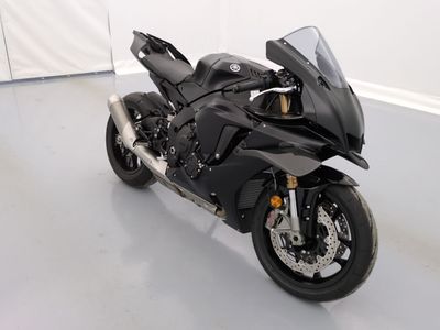une moto noire garée dans une pièce aux murs blancs