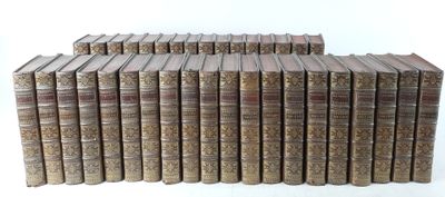 several old books stacked on top of each other on a white surface