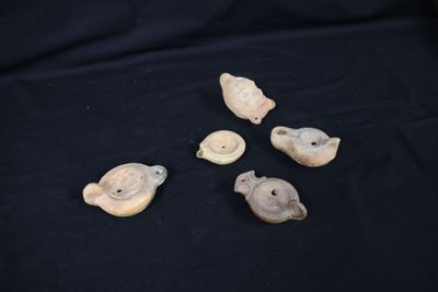 four small pieces of pottery sitting on top of a black cloth