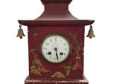 une horloge rouge surmontée d'une cloche