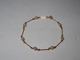 a close up of a bracelet with pearls on a white surface