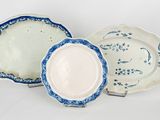 three blue and white plates sitting next to each other on a white surface