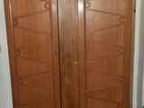 une photo d'une armoire en bois dans un coin d'une pièce