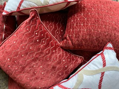 several red and white pillows and pillows on a carpeted floor