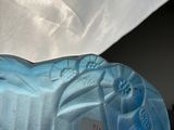 a close up of a blue shoe with a white umbrella in the background