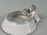 porcelain figurine of a boy and a dog sitting in a bowl