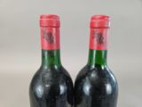 two bottles of wine sitting next to each other on top of a table