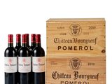 four bottles of wine in a wooden box on a white surface
