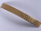 an image of a close up of a gold bracelet on a white surface