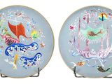 two decorative plates with designs on them on a white surface