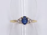 a close up of a ring with a blue sapphire and diamonds