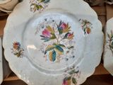 three plates with flowers on them sitting on a table