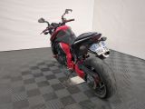 a red and black motorcycle parked on a black and white checkered floor