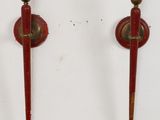 une paire de bougies rouges et en laiton sur fond blanc