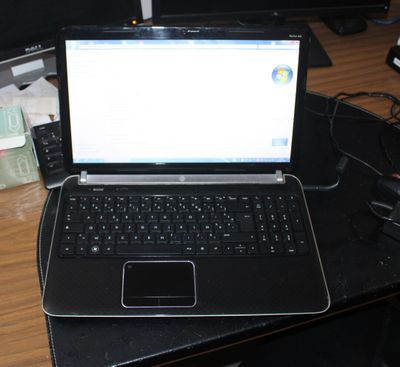 a laptop computer sitting on top of a black desk