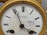 a gold clock with a dragon on the face