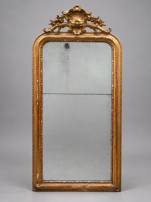 un grand miroir à cadre doré orné d'un motif décoratif