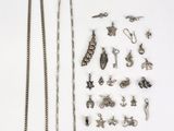 un assortiment de bijoux en argent posés sur une surface blanche, sur fond blanc