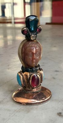 a statue of a man with a hat on top of a coin