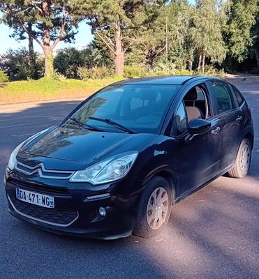 une petite voiture noire garée sur le bord de la route