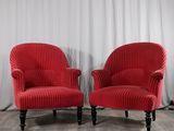 une paire de fauteuils rembourrés rouges devant un rideau blanc