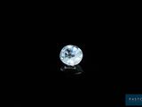 un diamant blanc sur une surface noire, avec un fond noir