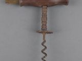 a close up of a corkscrew with a wooden handle on a gray background