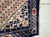 a rug hanging on the wall next to a toilet