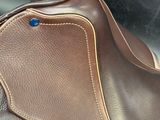 a close up of a saddle with a blue button on it