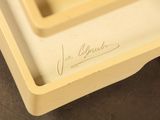 someone is writing on the bottom of a box with a knife