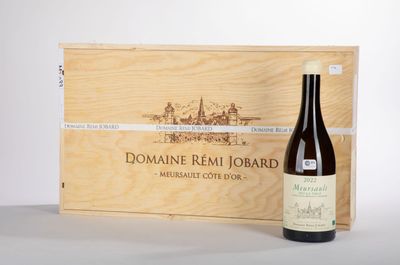 une bouteille de vin posée sur une table à côté d'une caisse en bois