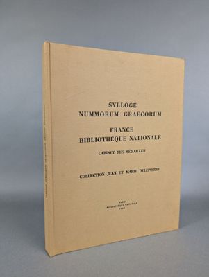 a brown book sitting on top of a table next to a gray wall