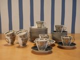 many cups and saucers sitting on a wooden table