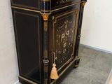 a black cabinet with a marble top and a clock on it