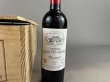 a bottle of wine sitting next to a wooden box