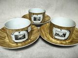 trois tasses à café et leurs soucoupes, ornées de motifs, posées sur une table