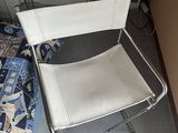 a white folding chair next to a bed in a room