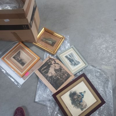 a box of framed pictures on the floor next to a box of framed pictures
