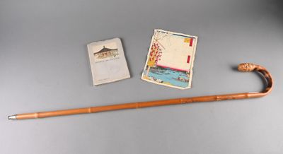 a cane, a book, and a card on a table