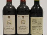three bottles of red wine sitting next to each other on a white surface