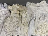trois paires de robes blanches exposées dans une vitrine