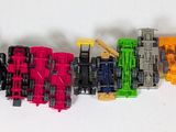 many toy trains that are lined up on a white surface