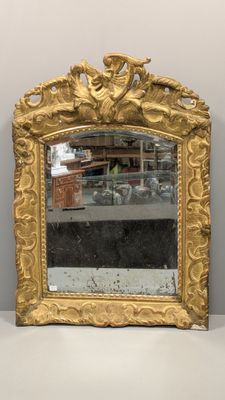 an image of a gold framed mirror sitting on top of a white table