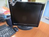 un écran d'ordinateur et un clavier posés sur un bureau en bois