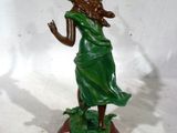 statue d'une femme en robe verte tenant un frisbee