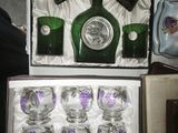 bottles and glasses in a box on a table next to a purse