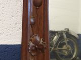 a mirror with a wooden frame and a motorcycle in the background