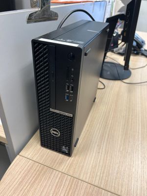 un ordinateur de bureau posé sur un pupitre en bois