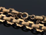 un gros plan d'un bracelet plaqué or sur un fond noir