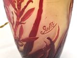 a glass vase with a red and yellow design on it